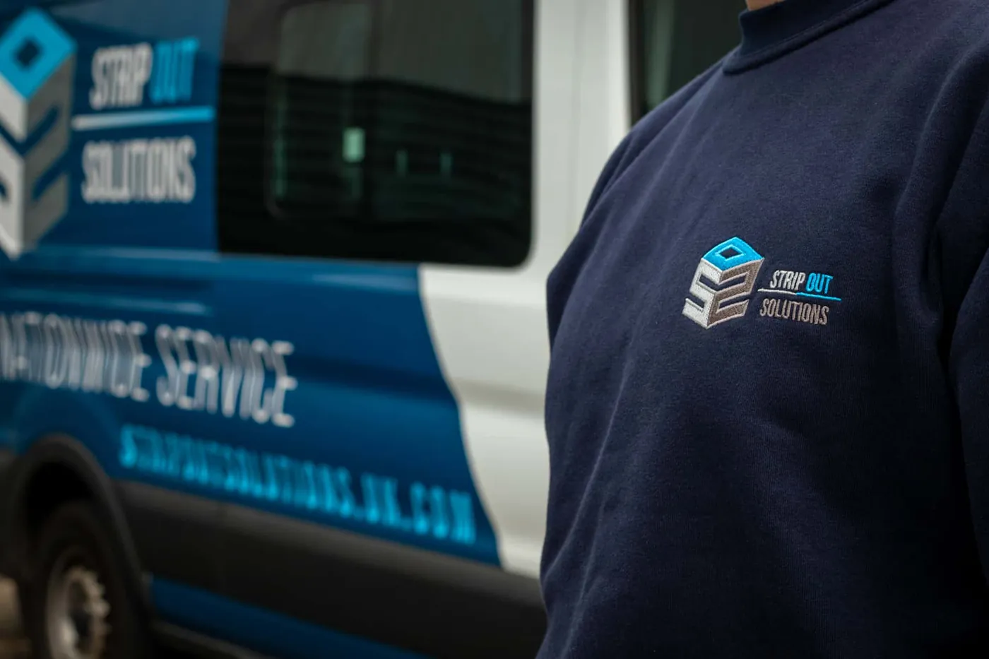 SOS branded workwear beside a liveried van