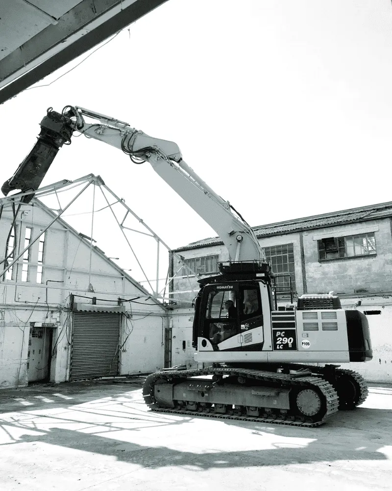 High-reach demolition rig taking down a structure